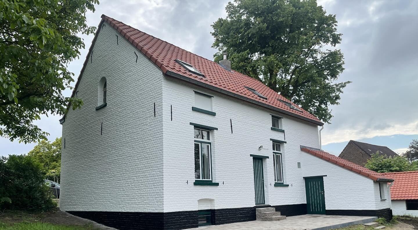 Een wit geverfde buitenmuur geschilderd door een professioneel